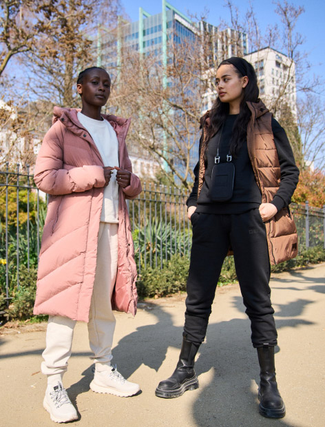 Two women standing in a city park