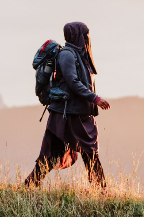 A woman with a daypack hiking
