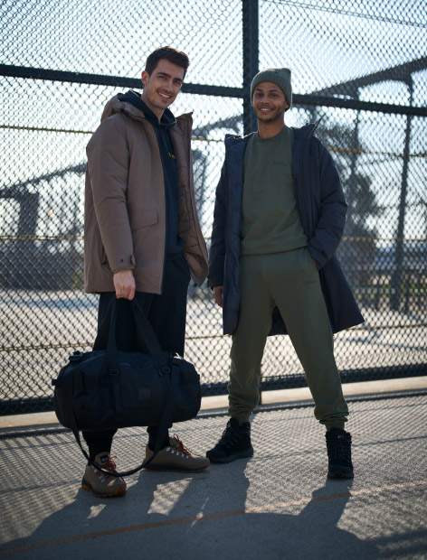 Two men standing and smiling towards the camera